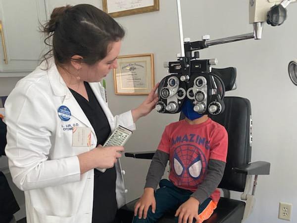 Photo of doctor giving an eye exam to a child.
